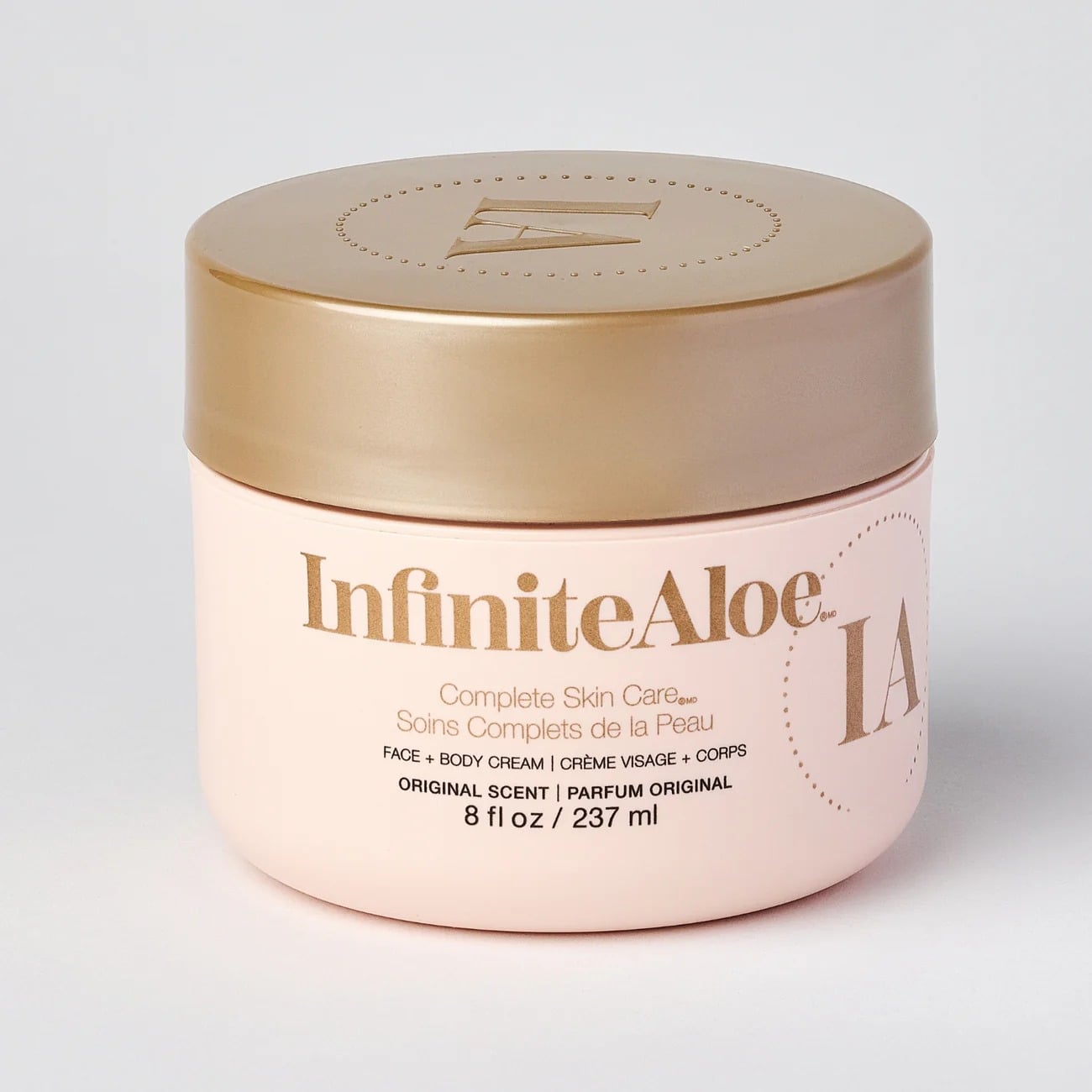An 8 fl oz Jar of InfiniteAloe Complete Skin Care Cream in Original Scent, round and light pink with a gold lid, featuring gold and gray label text for face and body.
