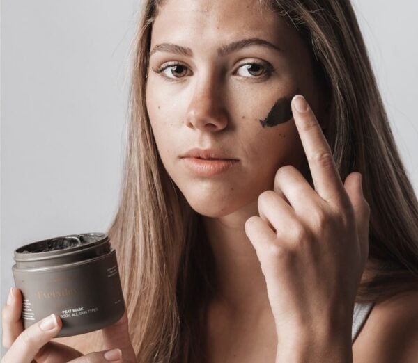 Woman applying Nordic Mud Peat Mask