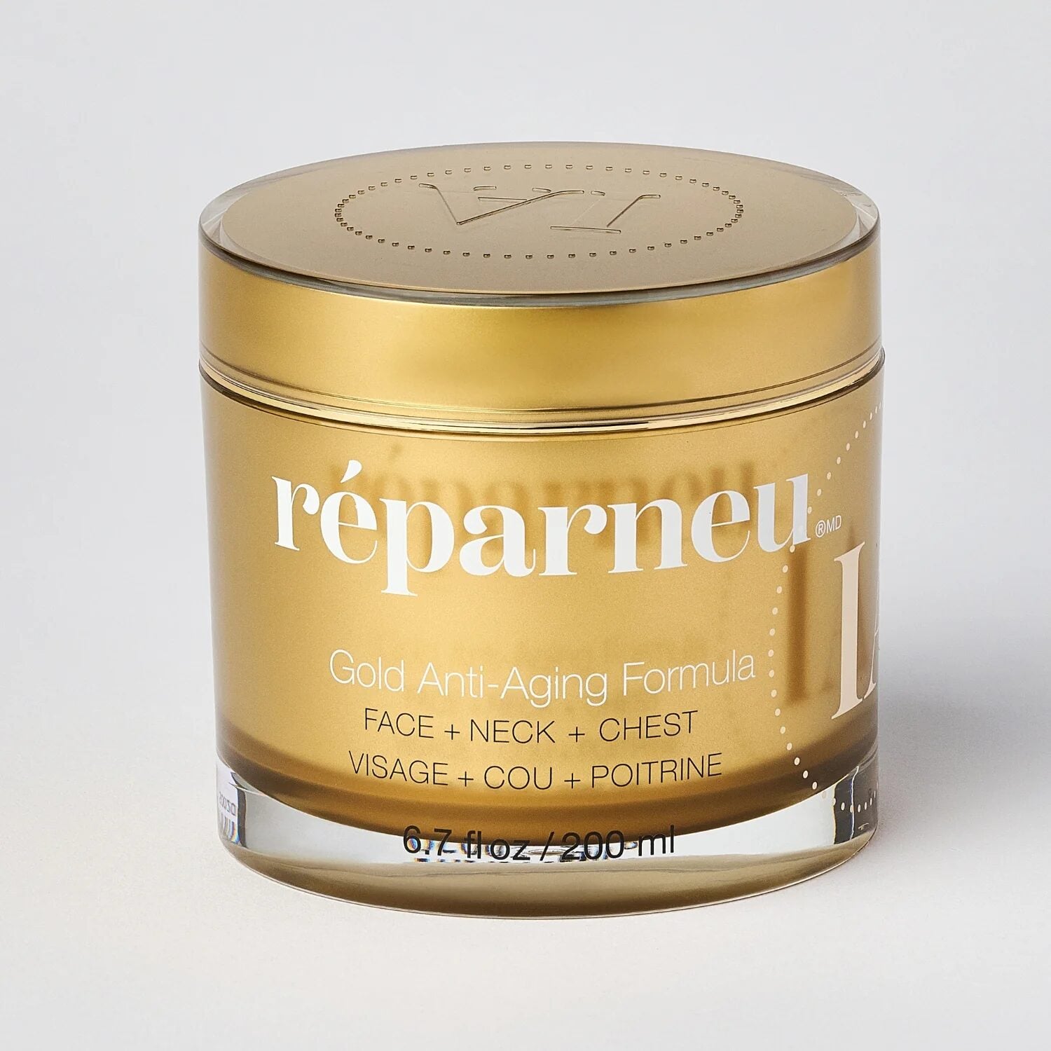 A closeup image shows a shiny gold jar labeled "réparneu Gold Anti-Aging Formula" for face, neck, and chest. The 6.7 fl oz/200 ml size appears on the bottom, and the jar features a matching gold lid.